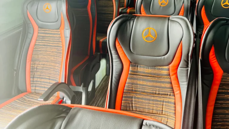 Leather seating with orange trim inside a Mercedes-Benz passenger coach