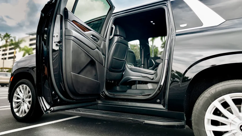Rear door of a black Escalade open to show the second-row seats