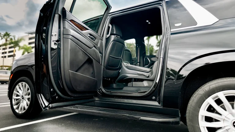 Rear door of a black Escalade open to show the second-row seats