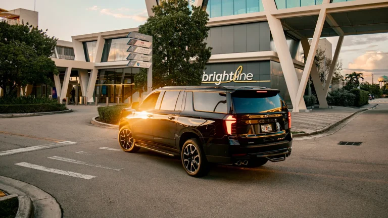 Black Suburban outside a Brightline station at sunset