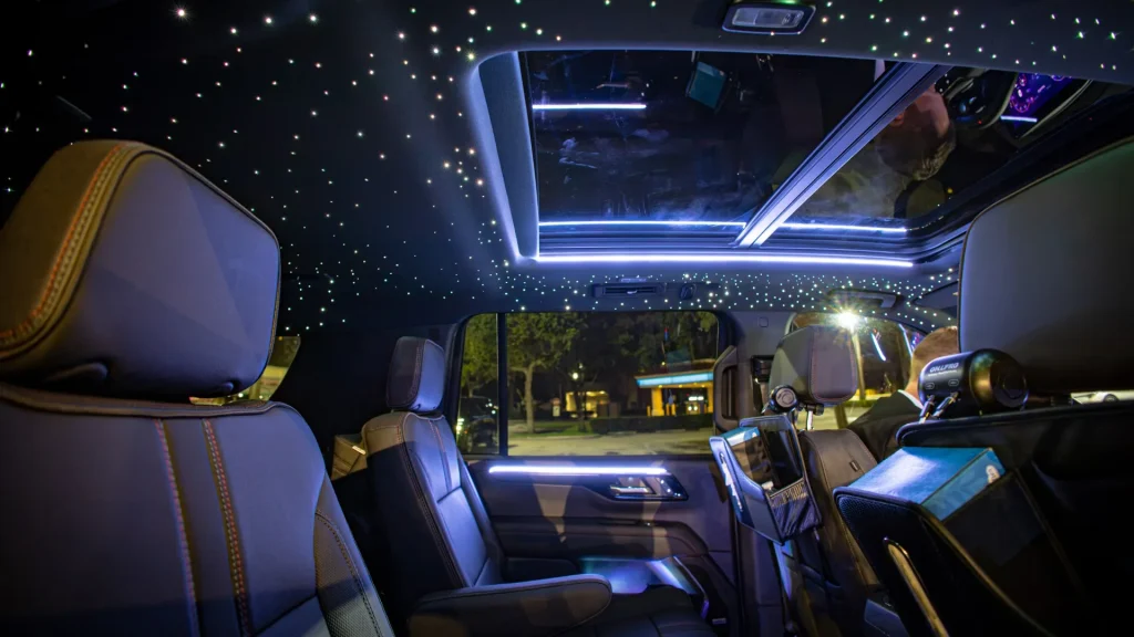 Captain's chairs and starlight ceiling inside a black Suburban at night