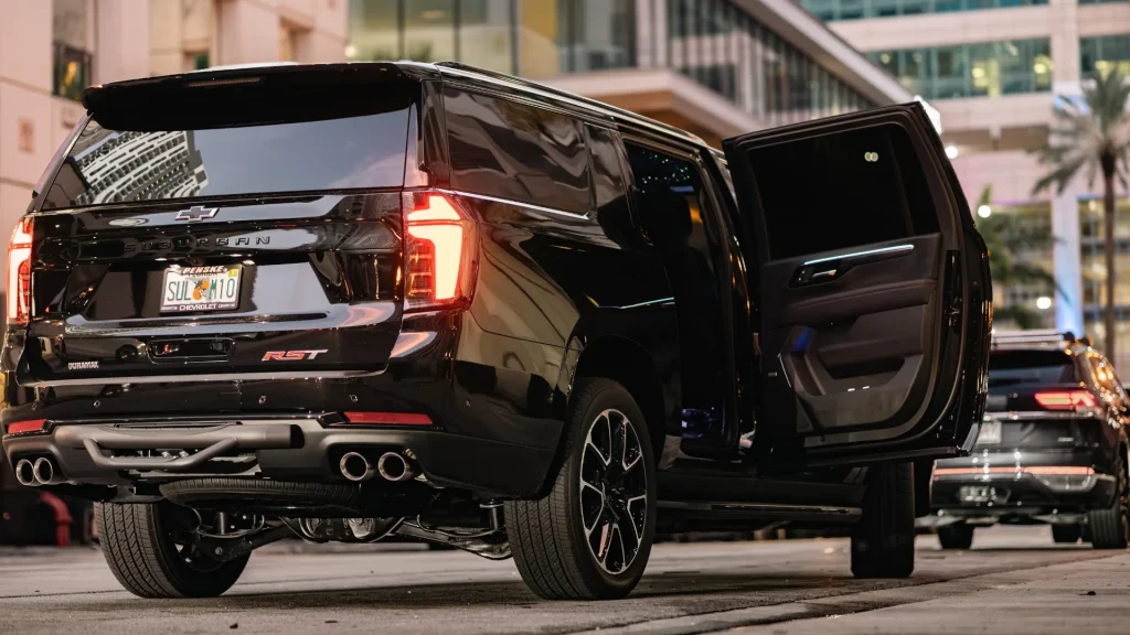 Black Suburban with its rear door open on a Brickell street at night