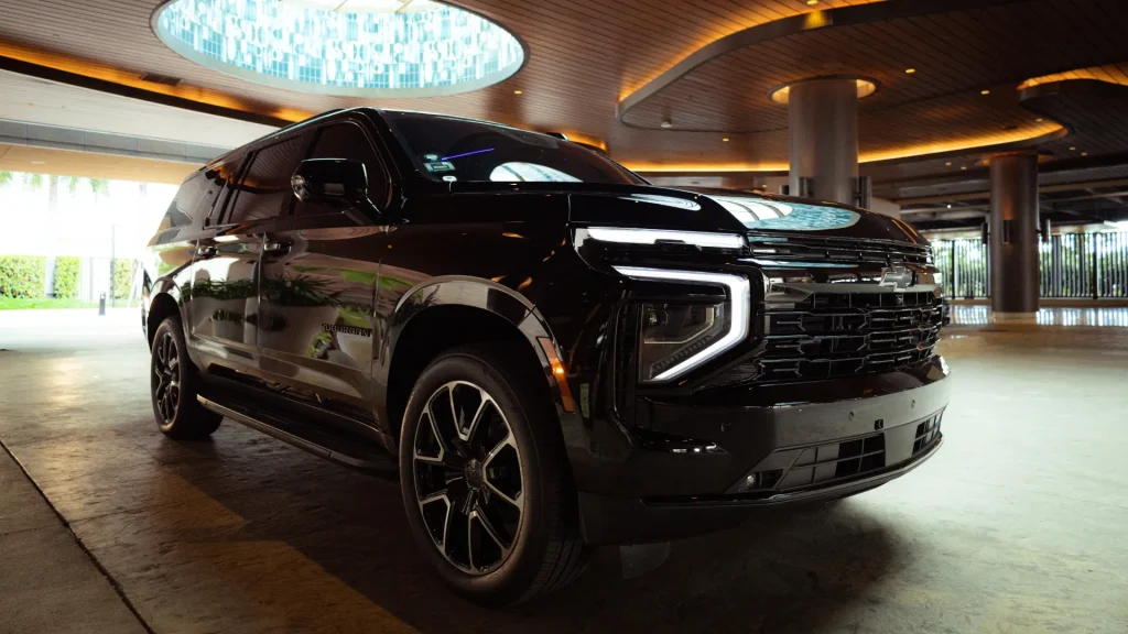 Black Chevrolet Suburban RST under a lit hotel porte-cochère