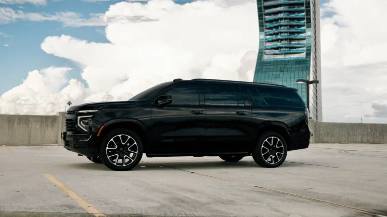 Side profile of a black Chevrolet Suburban on a rooftop parking deck