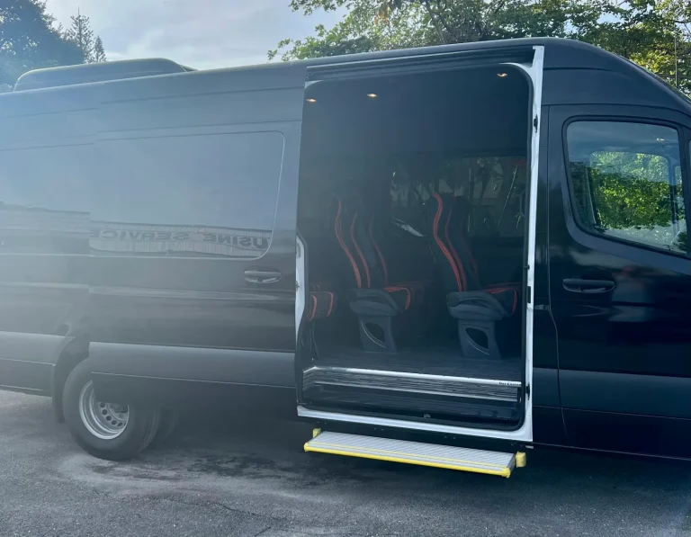 Side door open on a black passenger van with red seats